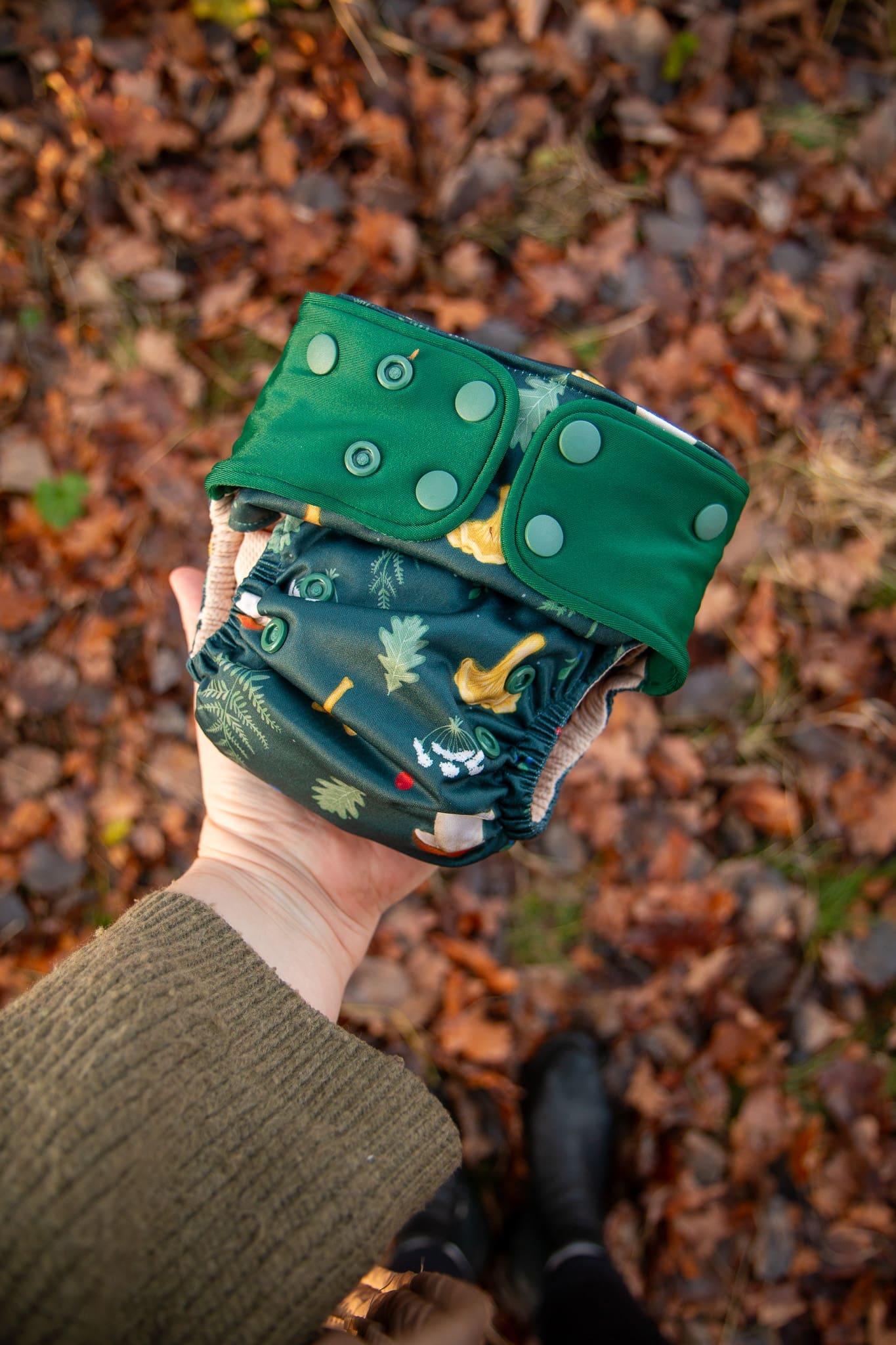 en modern tygblöja med svampar på och grönt tema