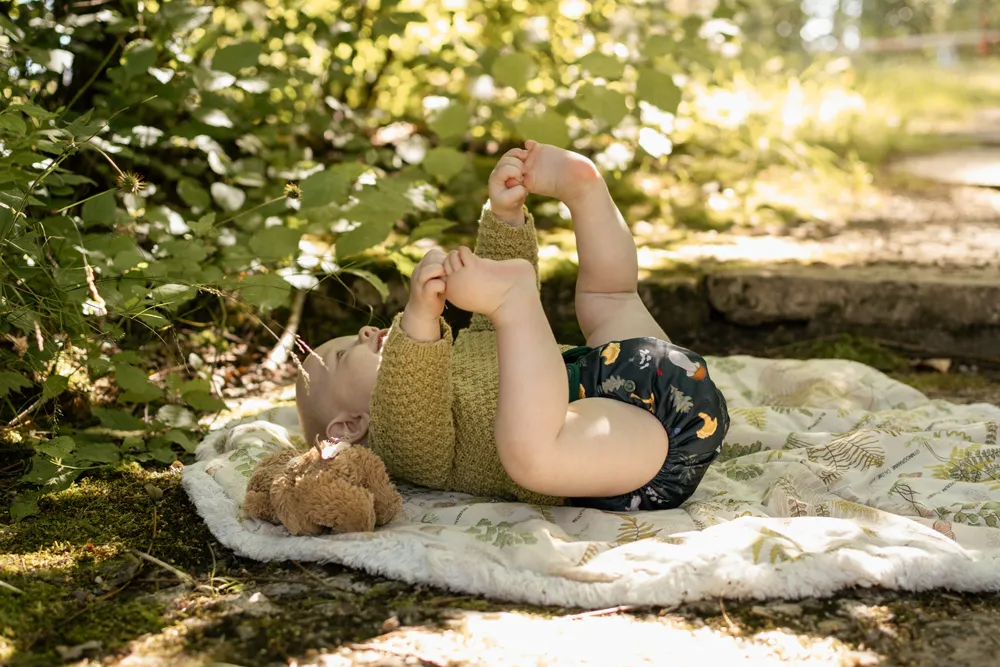 barn som ligger ner på rygg i en tygblöjoa